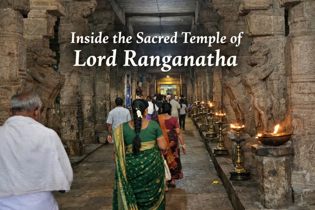 Devotees walking inside stone corridor of Sri Ranganathaswamy Temple Srirangam with carved pillars and oil lamps